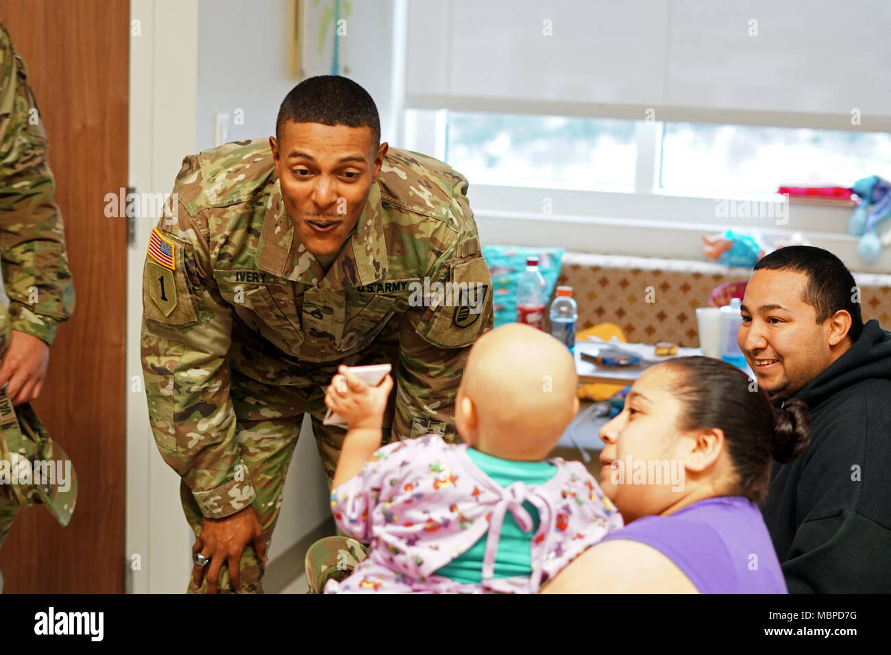 SAN ANTONIO, Texas - Staff Sgt. Bryan Ivery, nativo di Easley, South Carolina, trascorre del tempo con Ariana G., e i suoi genitori, durante un evento di divulgazione presso l' Università di sistemi sanitari Ospedale con gli Stati Uniti Esercito ciotola All-American, Gen 2, 2018. Il programma AAB dimostra l impegno dell esercito in America a favore della gioventù e migliora l'esercito, il collegamento con il popolo americano attraverso questi eventi. Foto Stock