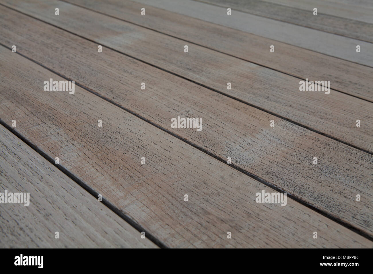 Un leggermente spiovente in legno di teak Tavolo da giardino, abstract  texture, potrebbe anche essere utilizzato per illustrare esterno altre  superfici in legno compresi decking Foto stock - Alamy