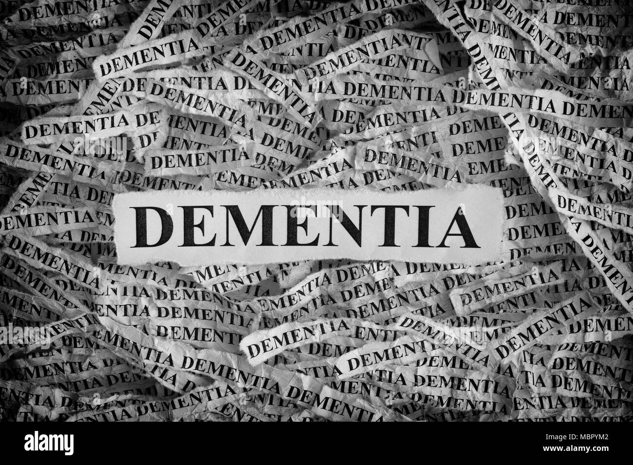 La demenza. Pezzi di carta strappati con la parola demenza. Concetto di immagine. In bianco e nero. Primo piano. Foto Stock