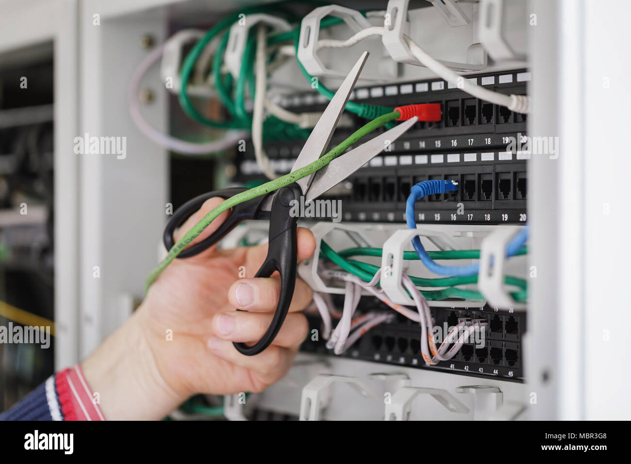Tagliare il cavo di rete con forbici e collegato alla apparecchiatura di comunicazione Foto Stock