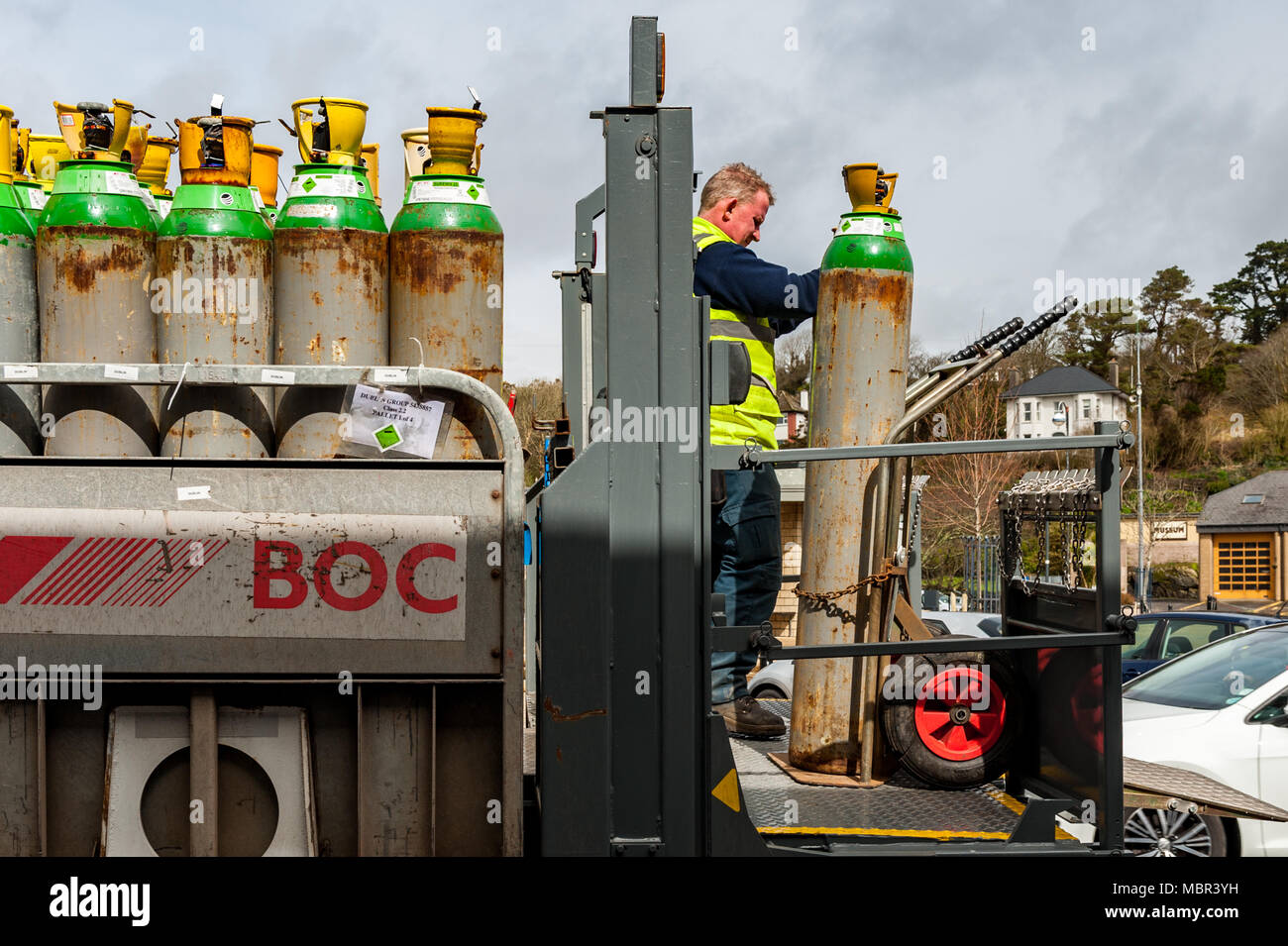 Dipendente di BOC offre una completa gamma di bombole di gas/cilindro per un pub di Bantry Town Square, Bantry, West Cork, Irlanda con copia spazio. Foto Stock