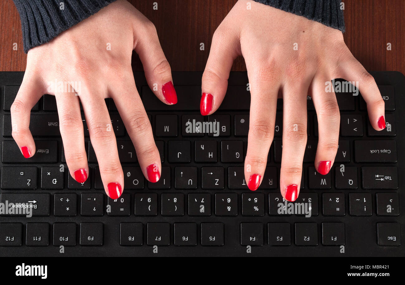 Mani femminili digitando sulla tastiera del computer sul tavolo. Close up. Vista dall'alto. Foto Stock