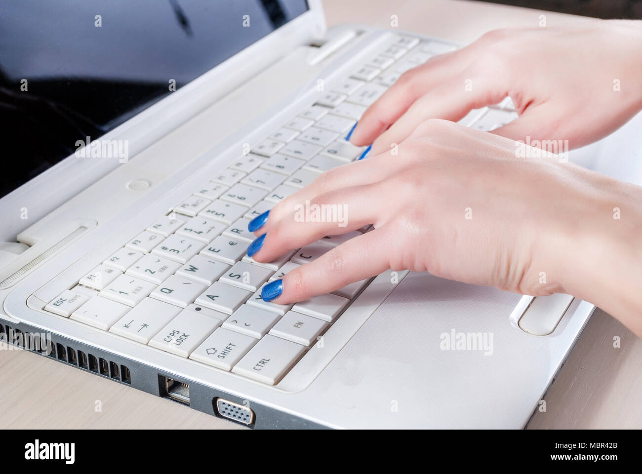 Mani femminili scrivere sulla tastiera del notebook in ufficio, vicino. Foto Stock