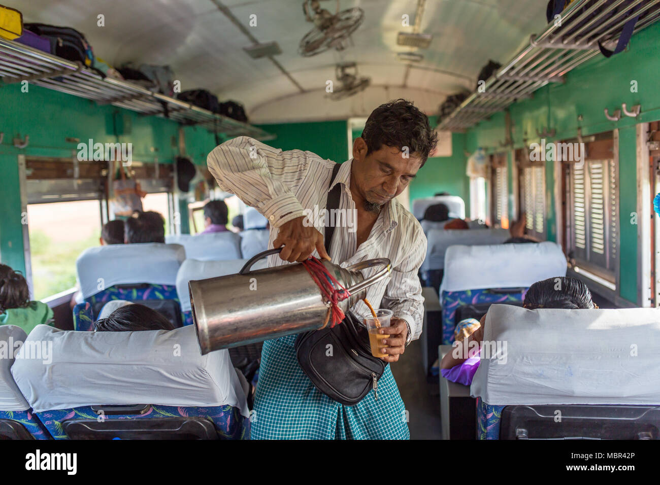 Yangon, Myanmar - 15 Ottobre 2016: Non identificato uomo birmano Vendita di tè in treno in Myanmar. Foto Stock