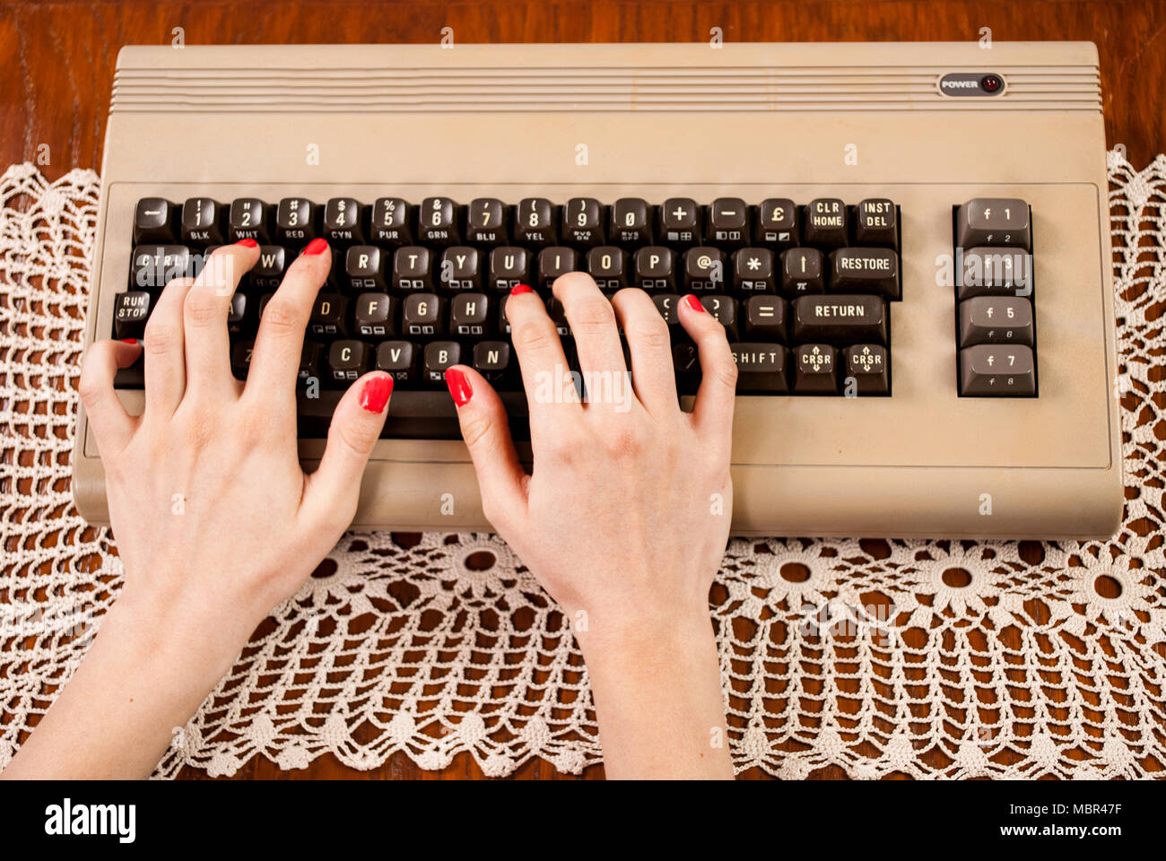 Donna digitando su una vecchia tastiera del computer Foto Stock