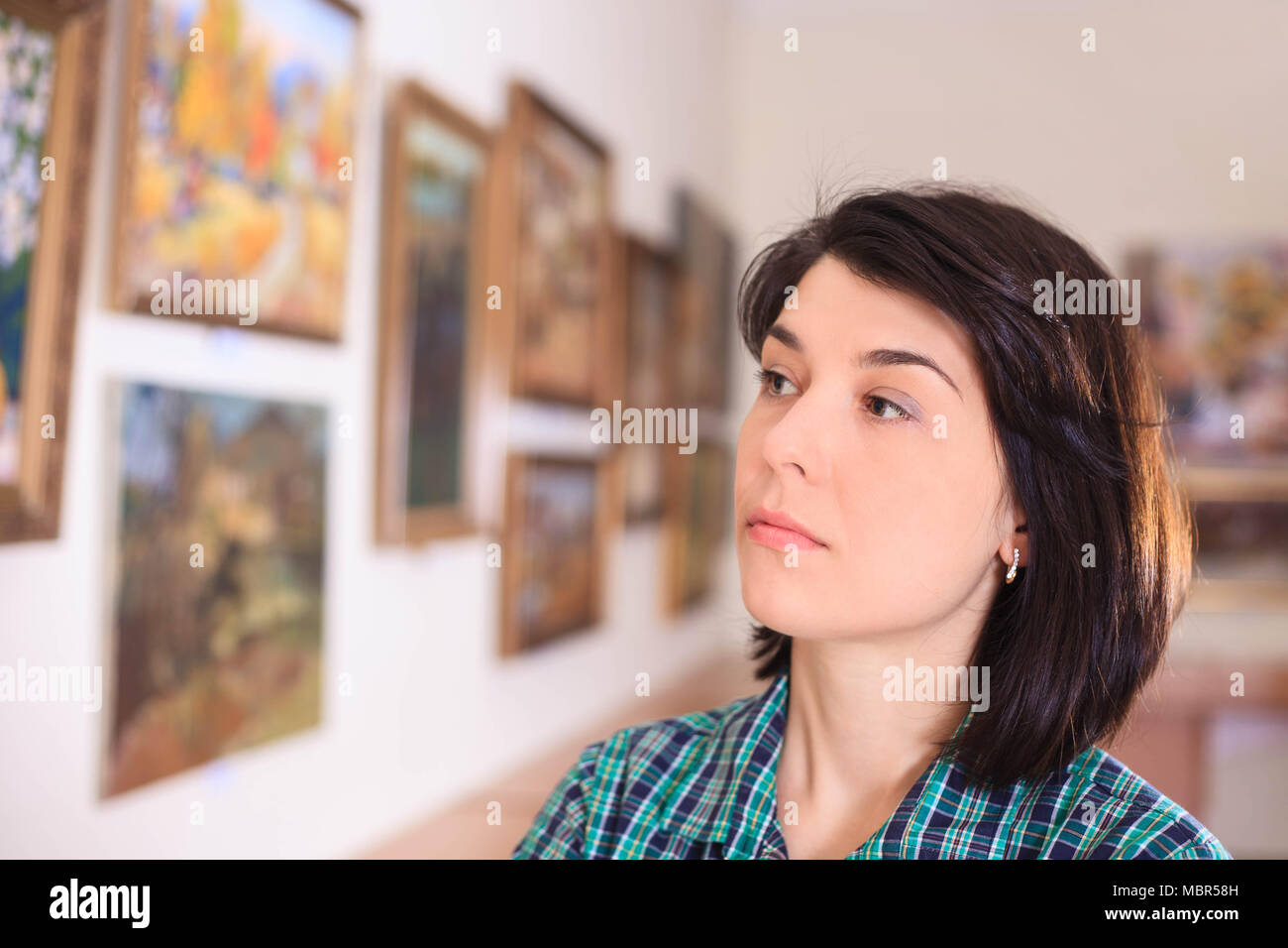 Giovane donna che guarda la pittura in galleria d'arte. Foto Stock