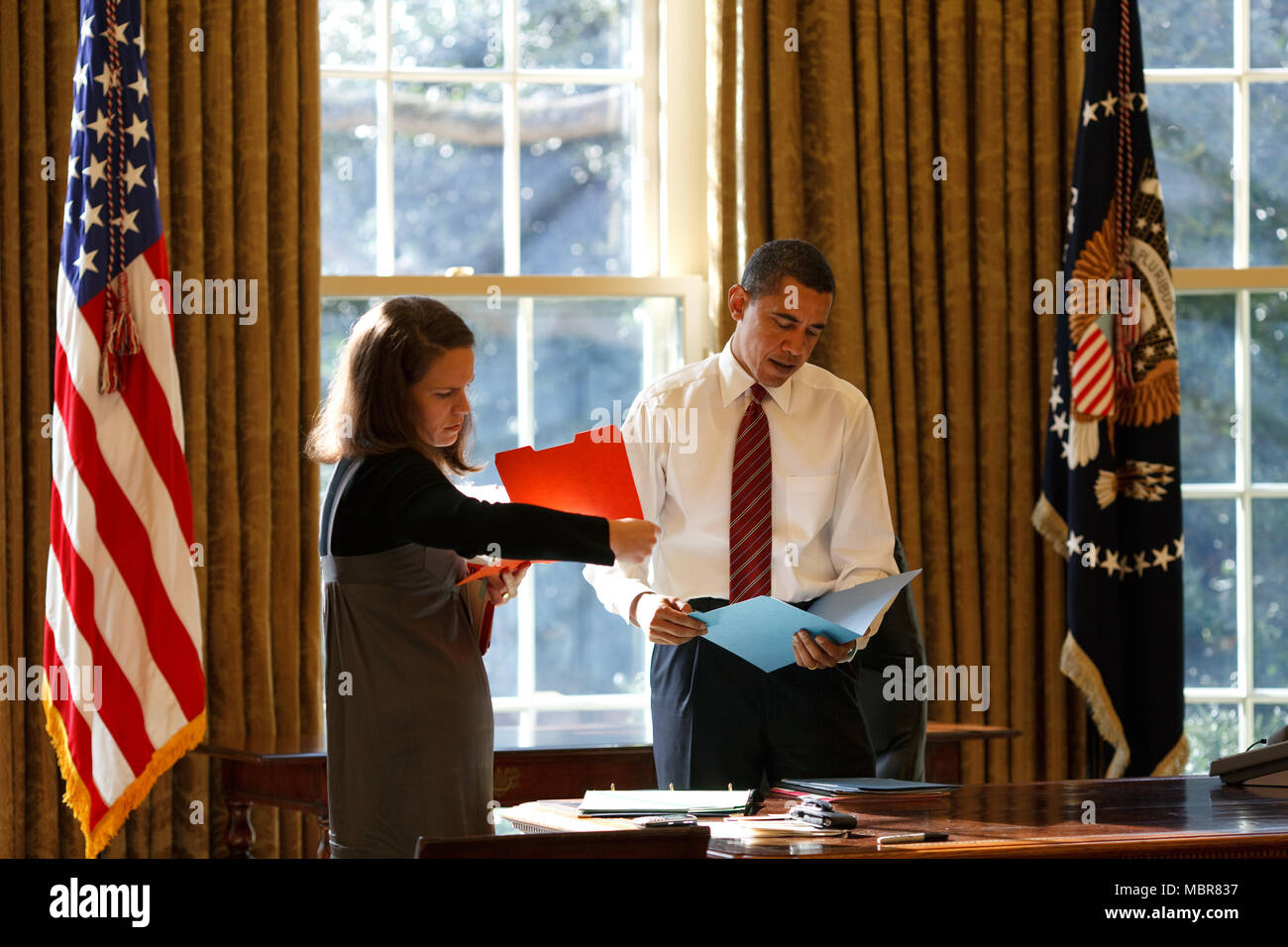Il presidente Barack Obama guarda la corrispondenza giornaliera nell'ufficio ovale con il suo segretario personale Katie Johnson 1/30/09. Gazzetta White House Photo by Pete Souza Foto Stock