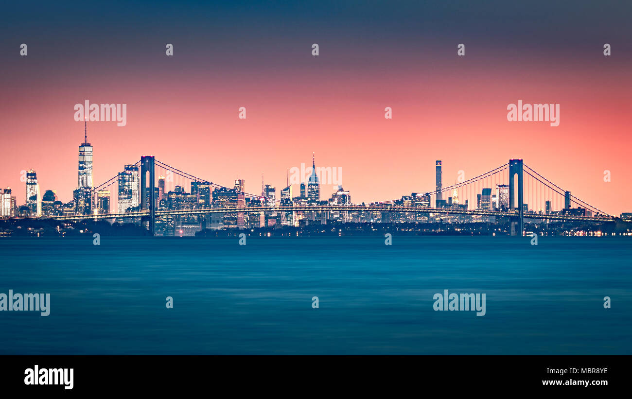 Verrazano Narrows Bridge cancelli di accesso superiore a New York Bay. Skyline di Manhattan sorge dietro il ponte. Foto Stock