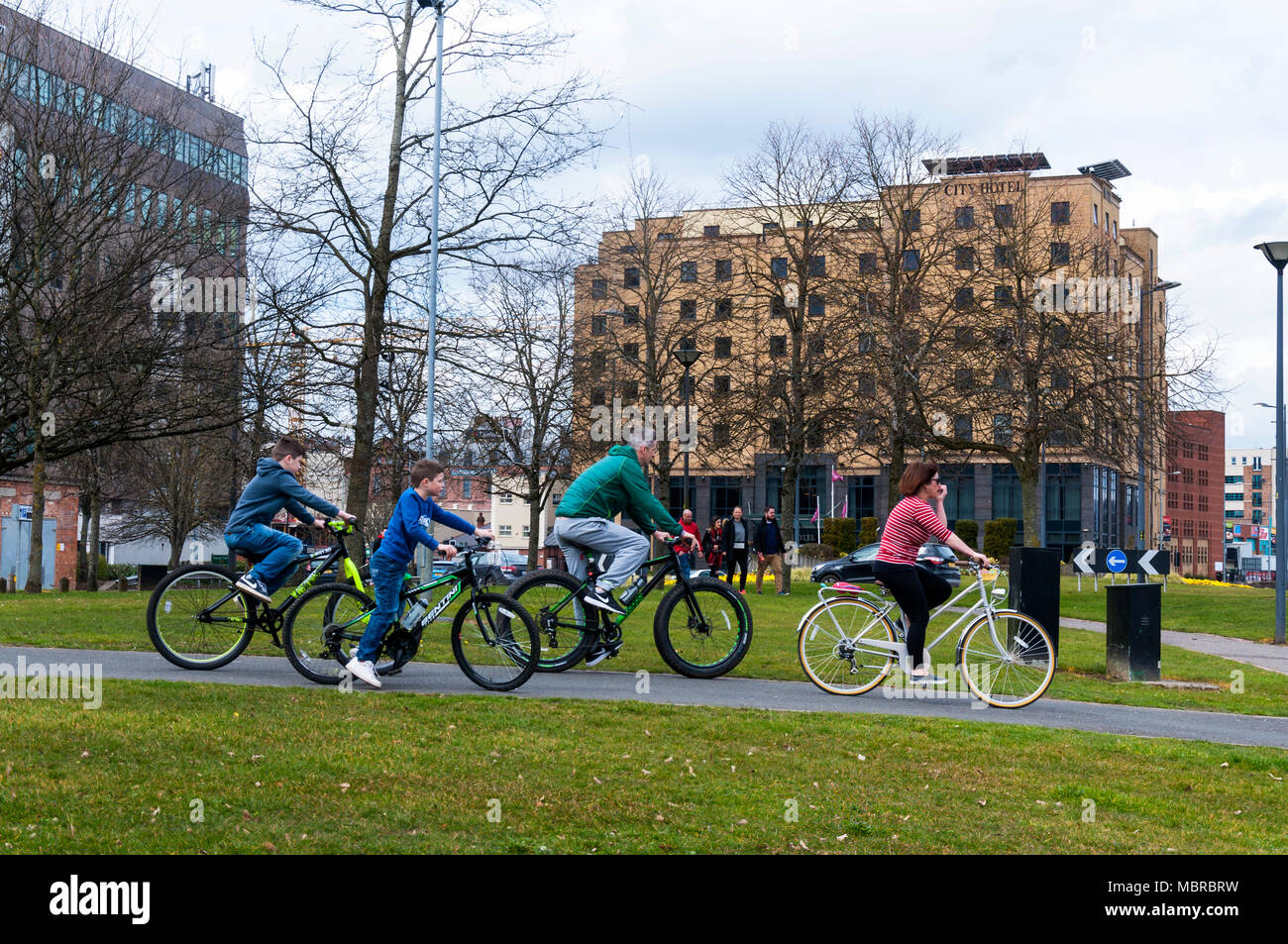 La famiglia in bicicletta nel Piazzale del Porto, Derry City, Londonderry, Irlanda del Nord, Regno Unito Foto Stock