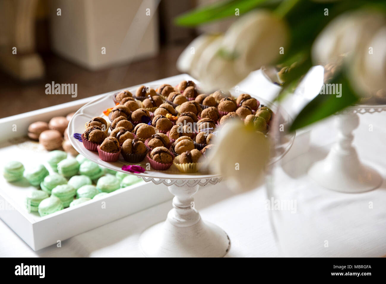 Primo piano di un buffet di nozze. Asciugare il cioccolato e pasticceria halzenut su un vintage riser metallici Foto Stock