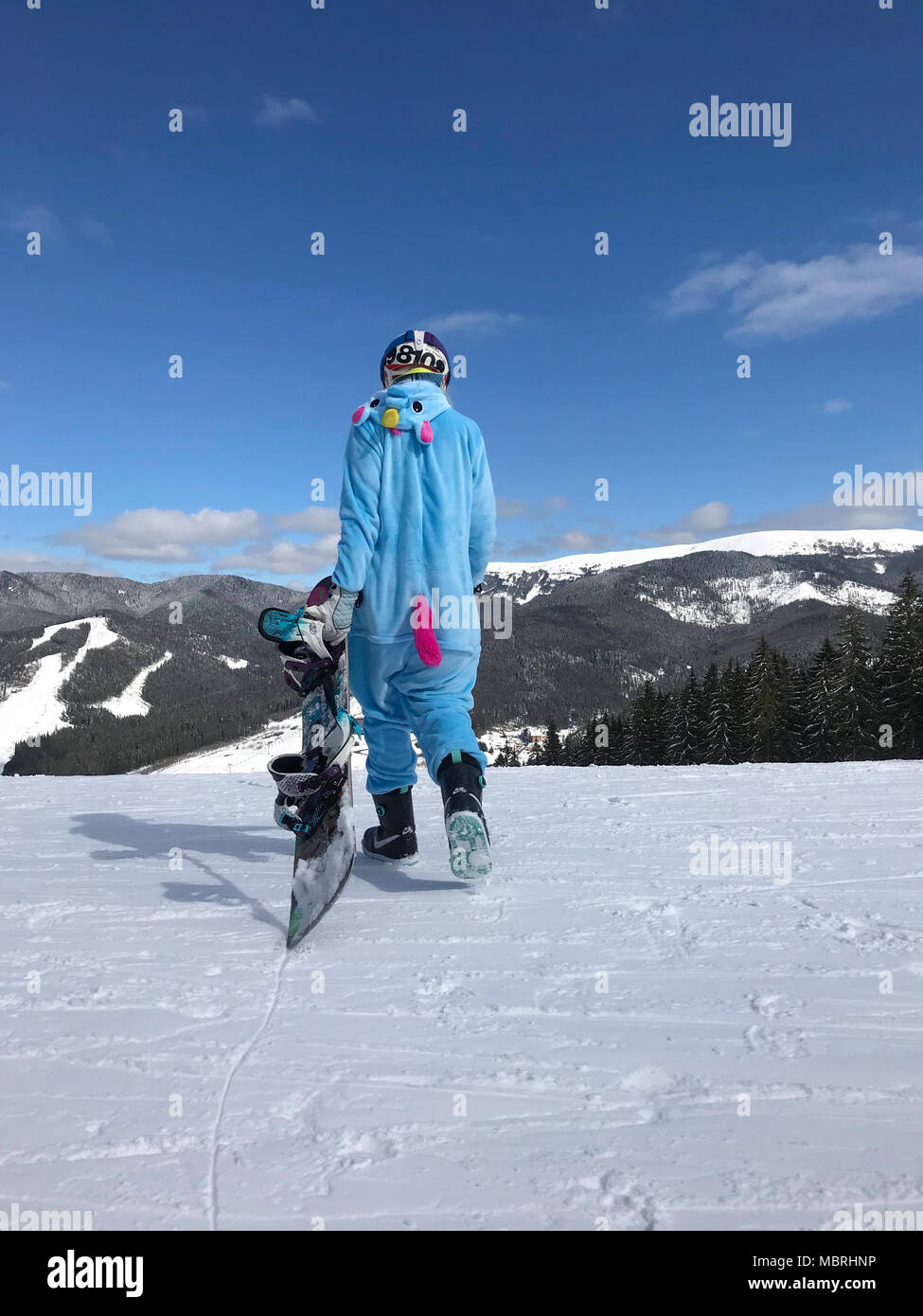 Ragazza in blu, rosa unicorn pigiama kigurumi outdoor con lo snowboard  sulla relazione di sci in neve montagne Foto stock - Alamy