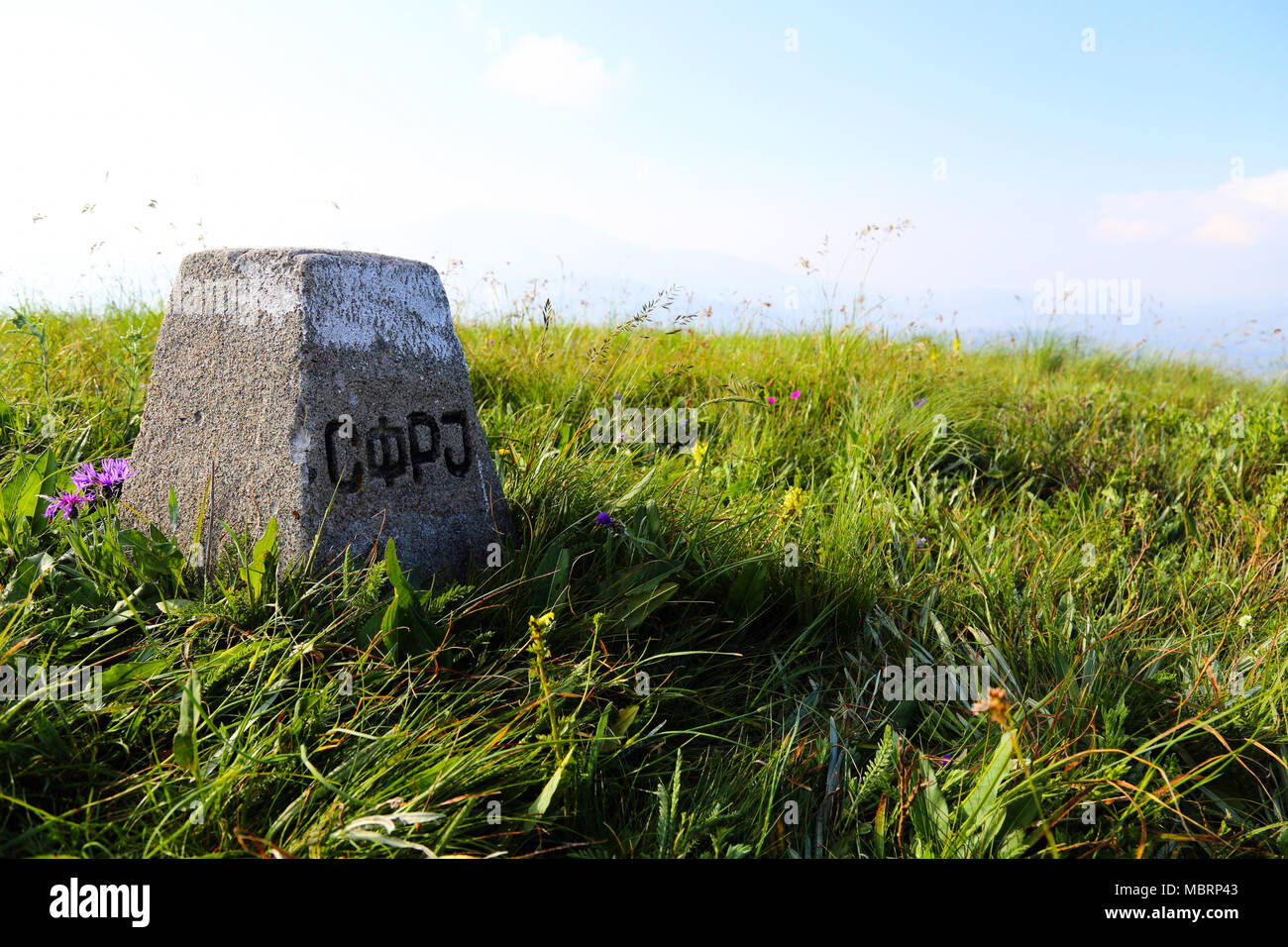 Storica pietra di confine con segno SFRJ (SFRJ) sociale della Repubblica federale di Iugoslavia al confine con l'Albania Foto Stock