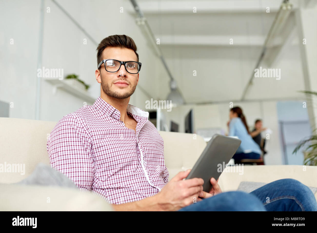 Uomo in bicchieri con tablet pc lavorando in ufficio Foto Stock