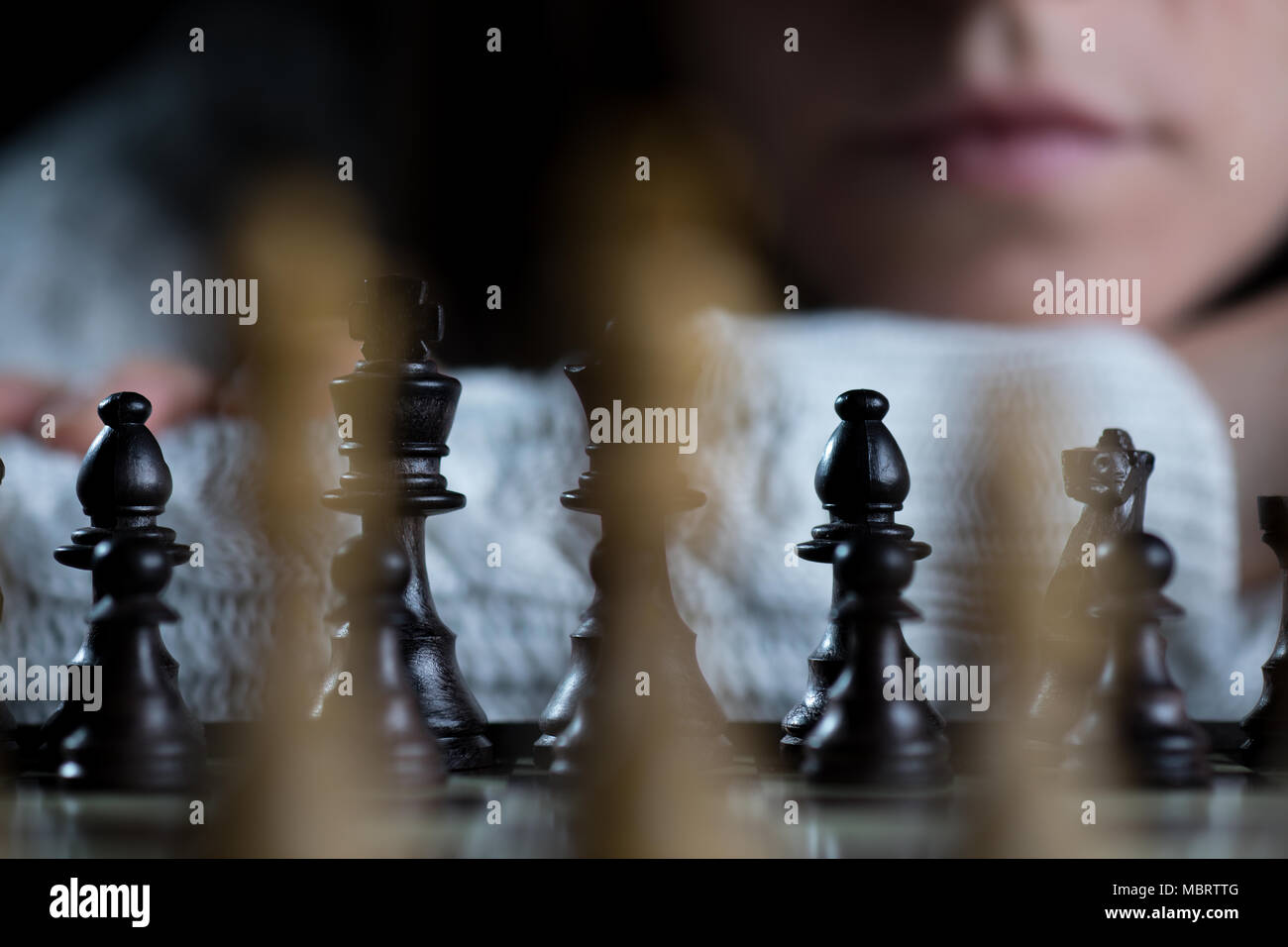 Grave donna giocando a scacchi a guardare la scacchiera Foto Stock