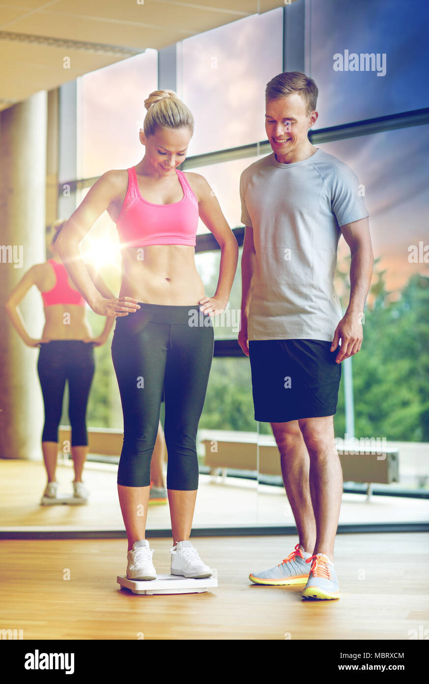 Uomo sorridente e donna con scale in palestra Foto Stock