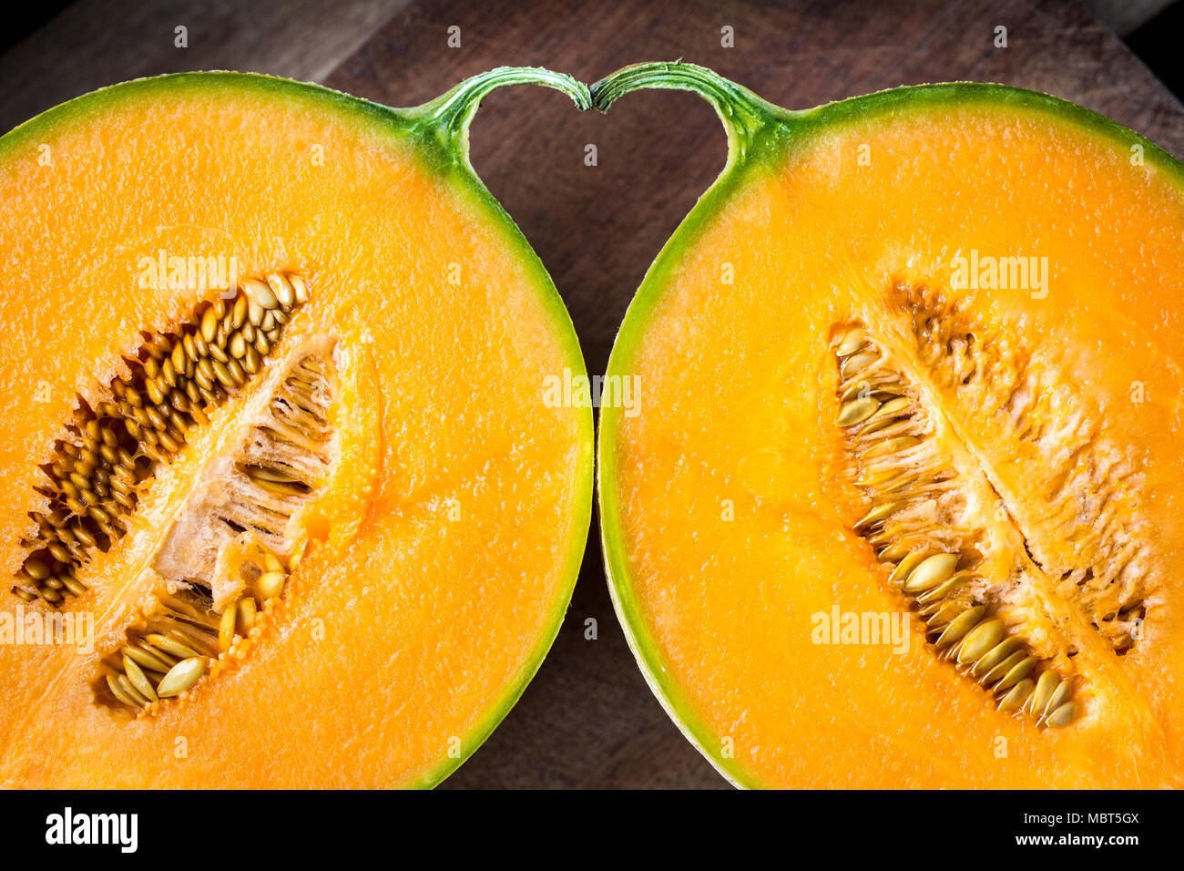 Lo spazio tra due metà di un melone e il picciolo costituisce una forma di cuore. Foto Stock