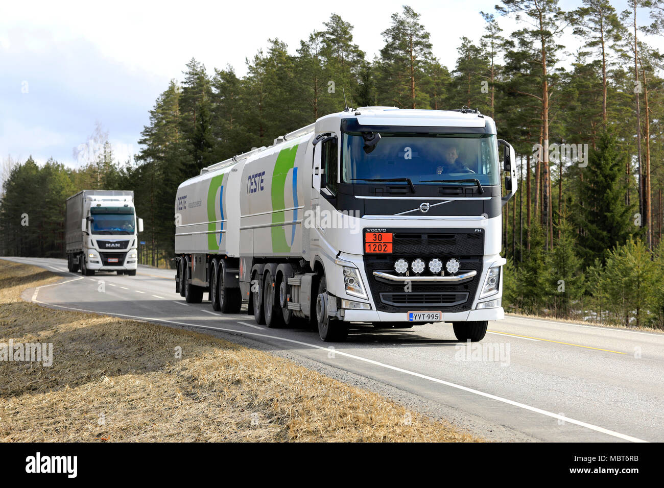 SALO, Finlandia - Aprile 6, 2018: Bianco Volvo FH Neste olio combustibile di petroliere e uomo semi rimorchio su strada nelle zone rurali del sud della Finlandia nella primavera. Foto Stock