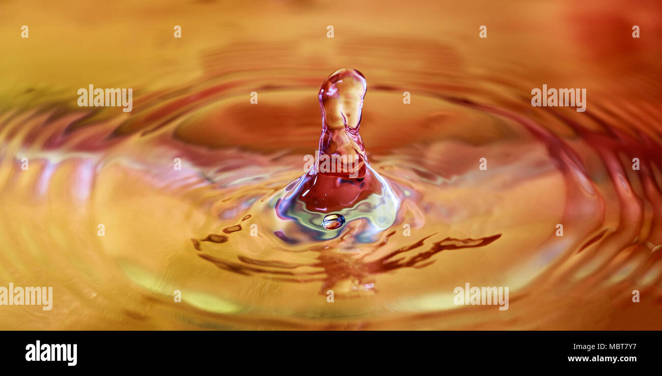 Colorato goccia d'acqua splash in acqua macrofotografia Foto Stock