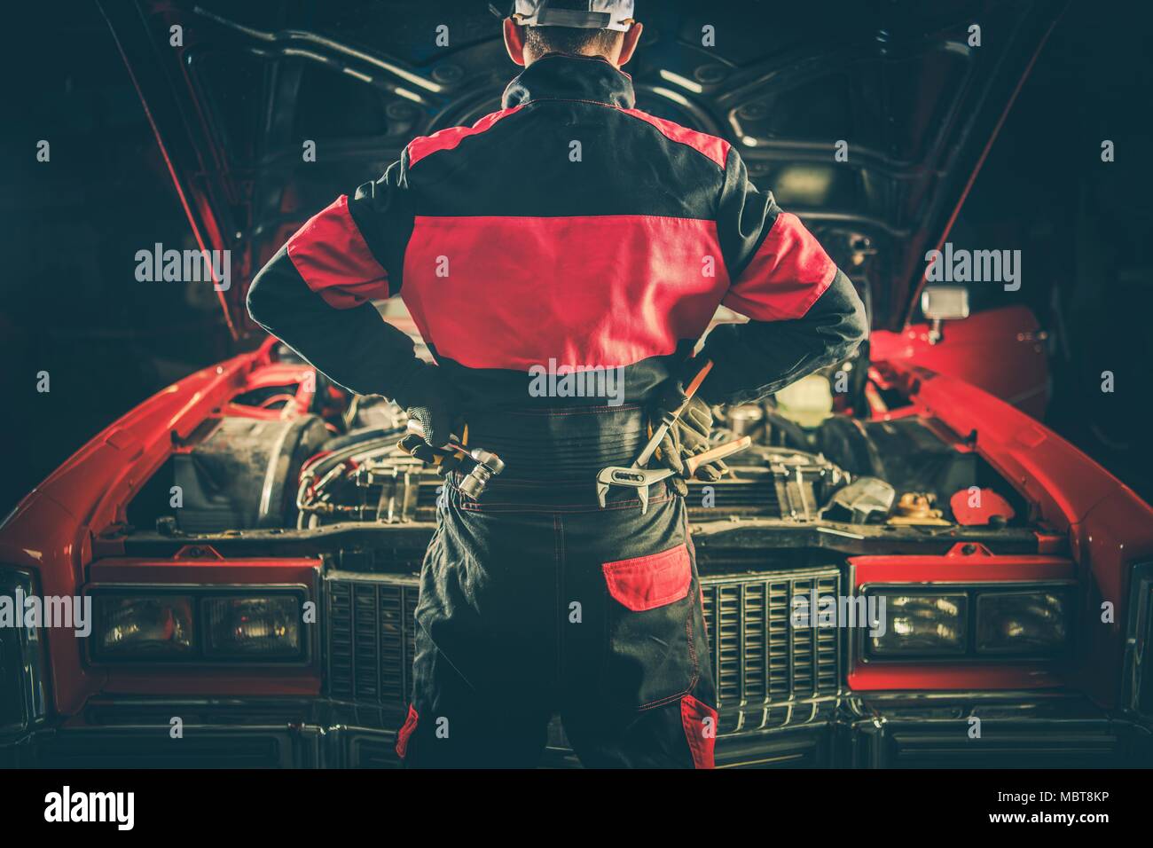 Auto d'epoca sfida di riparazione. Classic Car meccanico con strumenti nella parte anteriore del veicolo Vintage preparando per il suo lavoro per ottenere l'avviamento del motore. Foto Stock