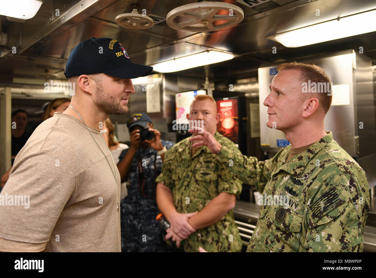 180111-N-ND356-0071 PEARL HARBOR (GEN. 11, 2018) ex National Football League (NFL) player Tim Tebow colloqui con Master Chief Sottufficiali della Marina Steven S. Giordano durante un tour del missile destroyer USS Chung-Hoon (DDG 93). (U.S. Foto di Marina di Massa lo specialista di comunicazione di terza classe Jessica O. Blackwell) Foto Stock