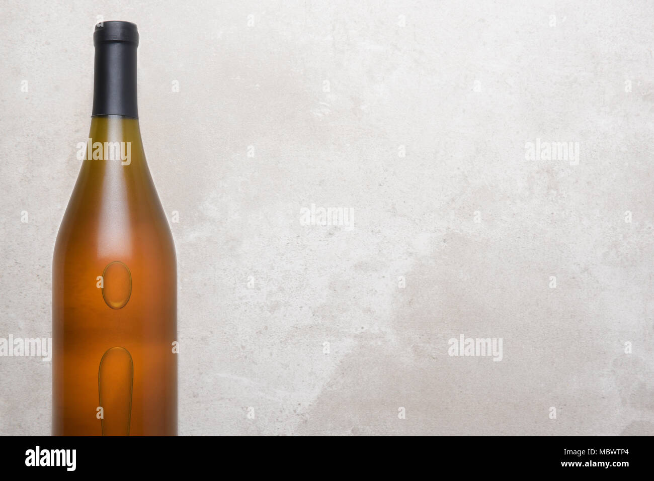 Lo Chardonnay Vino: vista dall'alto di una bottiglia singola su un contatore di calcestruzzo top. Bottiglia è impostato su lato sinistro con un ampio spazio di copia. Foto Stock