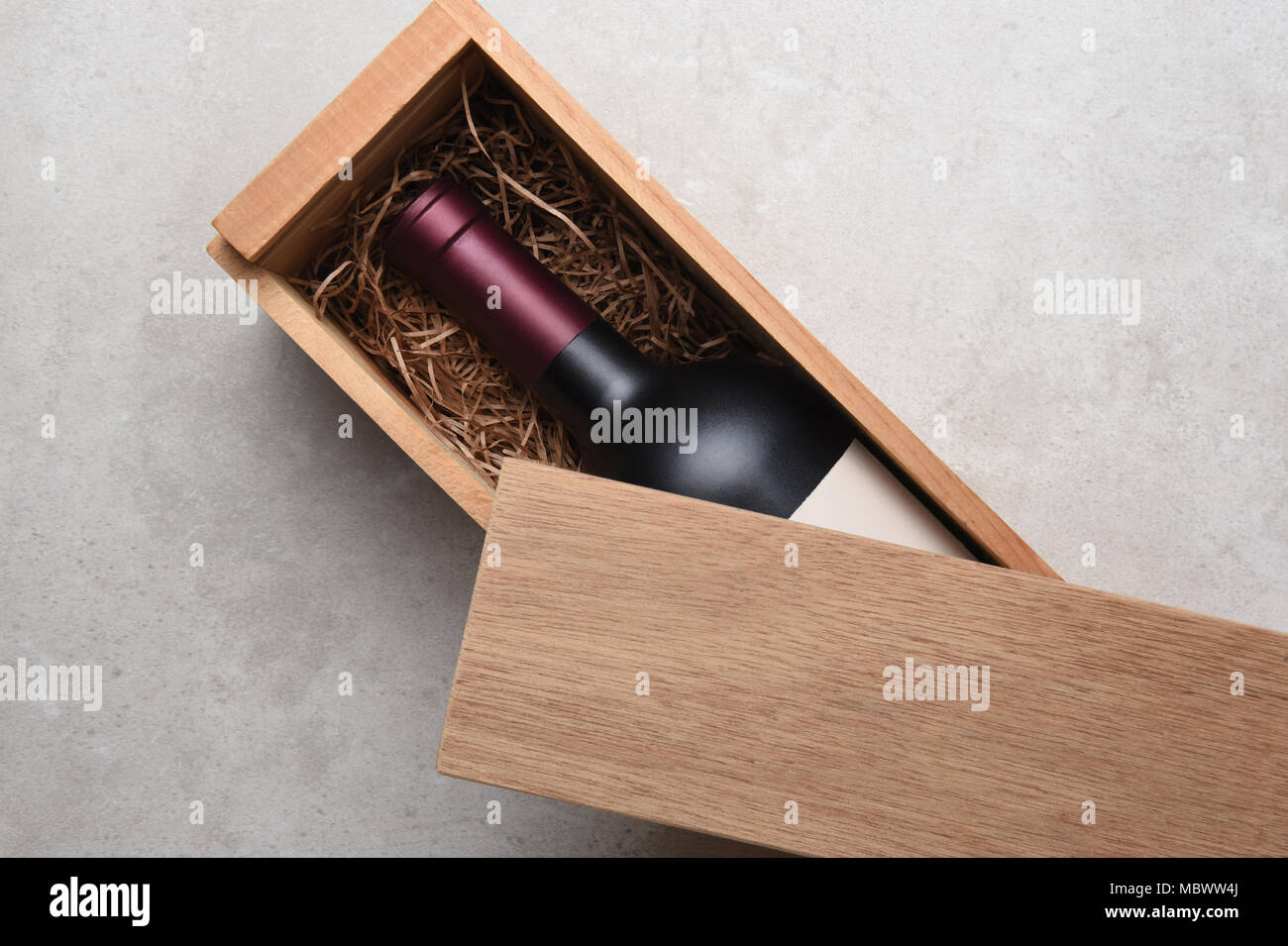 Cabernet vino Scatola: una sola bottiglia di vino rosso in una scatola di legno parzialmente coperto con il suo coperchio. Foto Stock