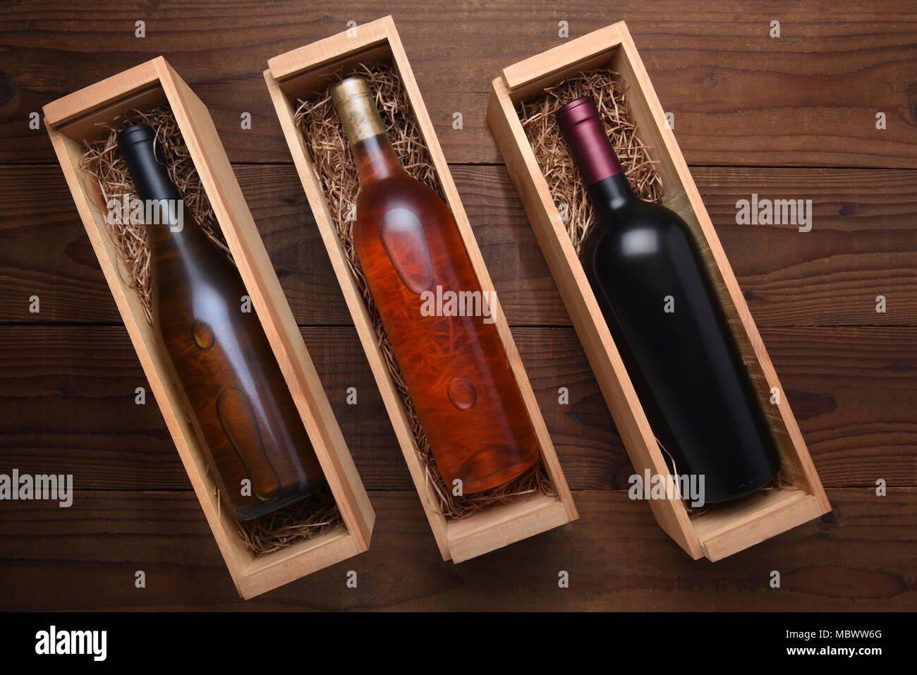 Tre scatole di vino: Blush, Cabernet e Chardonnay bottiglie di vino in singoli casi con paglia di imballaggio. Foto Stock