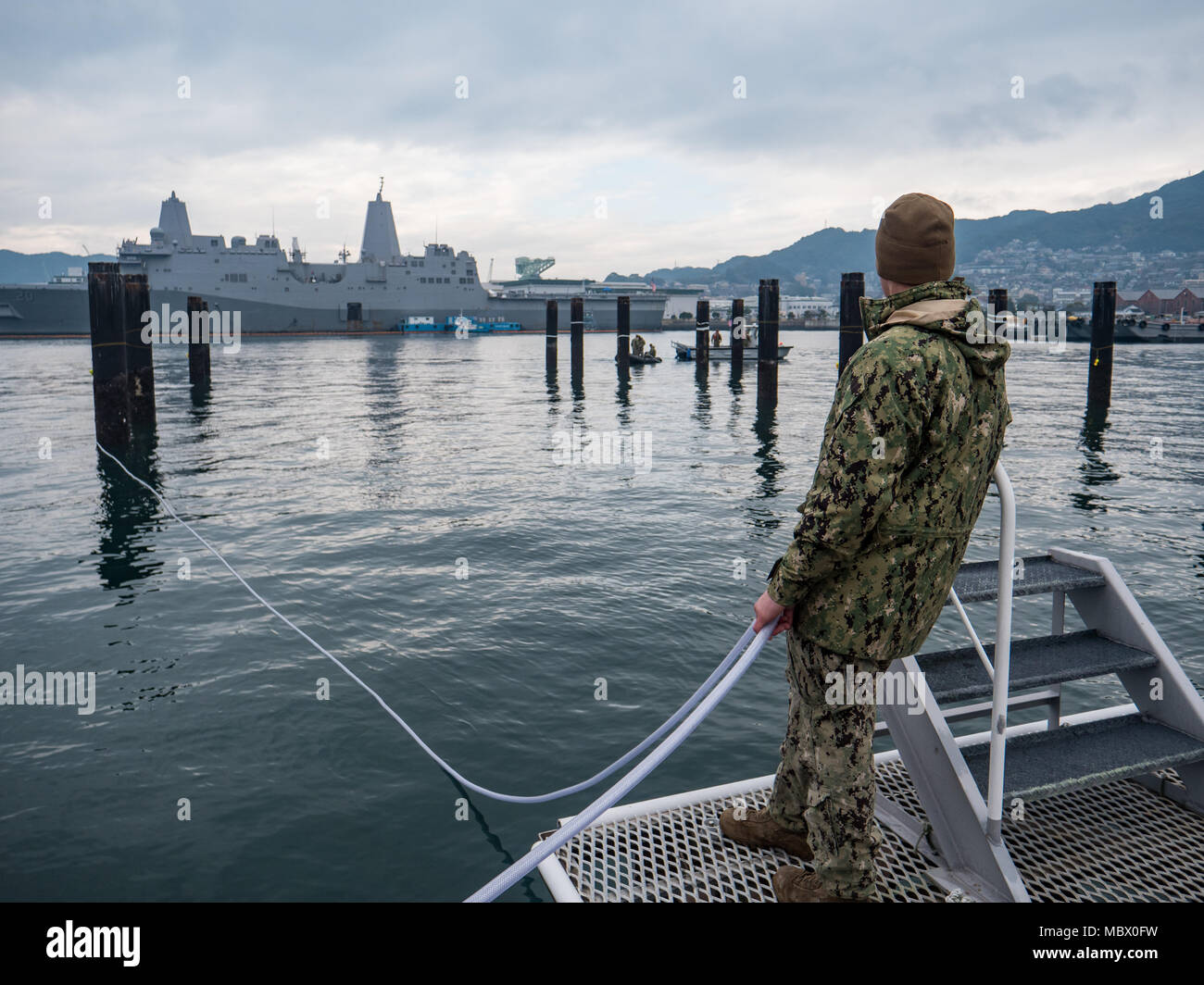 Stati Uniti Costruzione navale meccanico di terza classe Lucas Jackson, assegnato alla costruzione subacquea Team (UCT) 2, luoghi di una cortina di bolle tubo flessibile per aria compressa per soffiare la protezione d'onda un al comandante, le attività della flotta Sasebo (CFAS), Gennaio 15, 2018. UCT-2 fornisce la costruzione, ispezione, manutenzione e riparazione di subacquea e waterfront strutture a sostegno della flotta del Pacifico. (U.S. Navy combattere la fotocamera dalle comunicazioni di massa Specialist 1a classe Arthurgwain L. Marquez) Foto Stock
