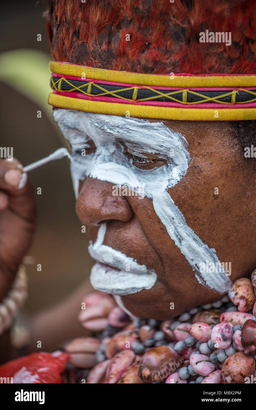 Una donna dipinto il suo viso prima di una performance, Mount Hagen spettacolo culturale, Papua Nuova Guinea Foto Stock