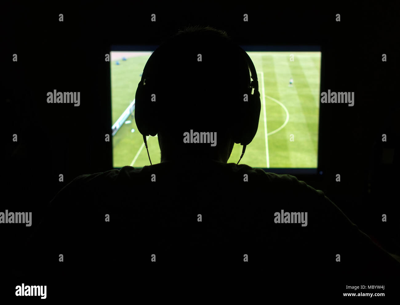 L'uomo nelle cuffie giocare computer gioco del calcio di notte. Foto Stock