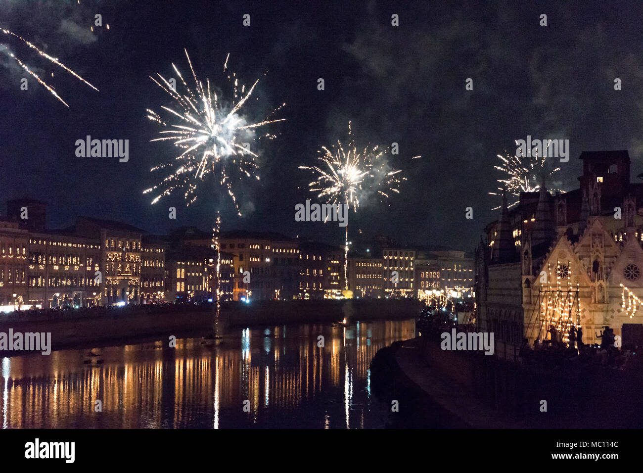 Coloratissimi fuochi d'artificio illuminano il cielo sopra il fiume Arno in onore del santo San Ranieri a la luminaria annuale festival che si tiene ogni anno il 16 giugno Foto Stock