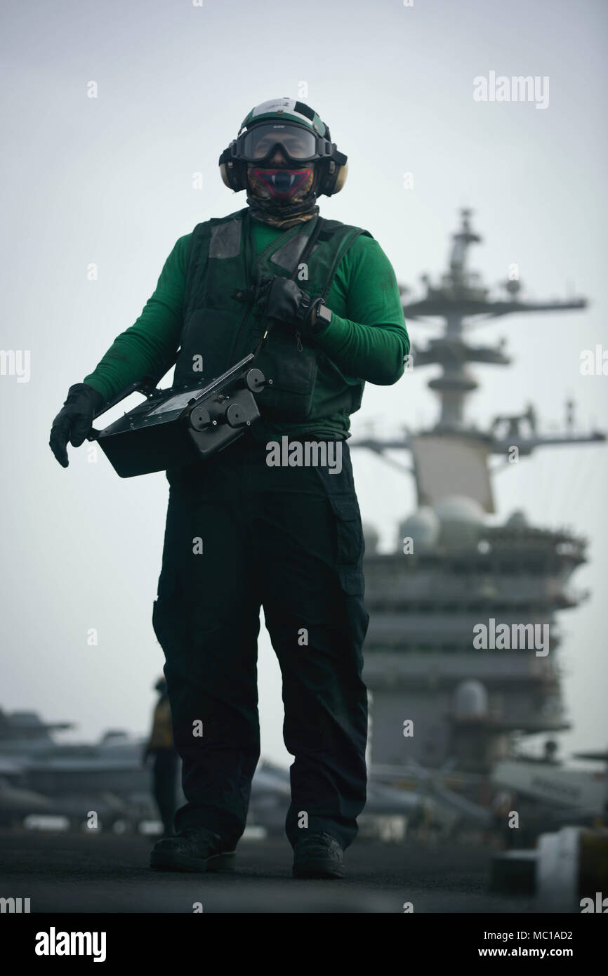 180121-N-NG033-1134 GOLFO ARABICO (GEN. 21, 2018) Airman Jean Ortiz stand by per pesare su aeromobili il ponte di volo della portaerei USS Theodore Roosevelt CVN (71). Theodore Roosevelt e il suo supporto strike gruppo sono distribuiti negli Stati Uniti Quinta Flotta area di operazioni a sostegno della sicurezza marittima operazioni per rassicurare gli alleati e partner e preservare la libertà di navigazione e il libero flusso di commercio nella regione. (U.S. Foto di Marina di Massa Specialista comunicazione Seaman Michael Hogan/rilasciato) Foto Stock