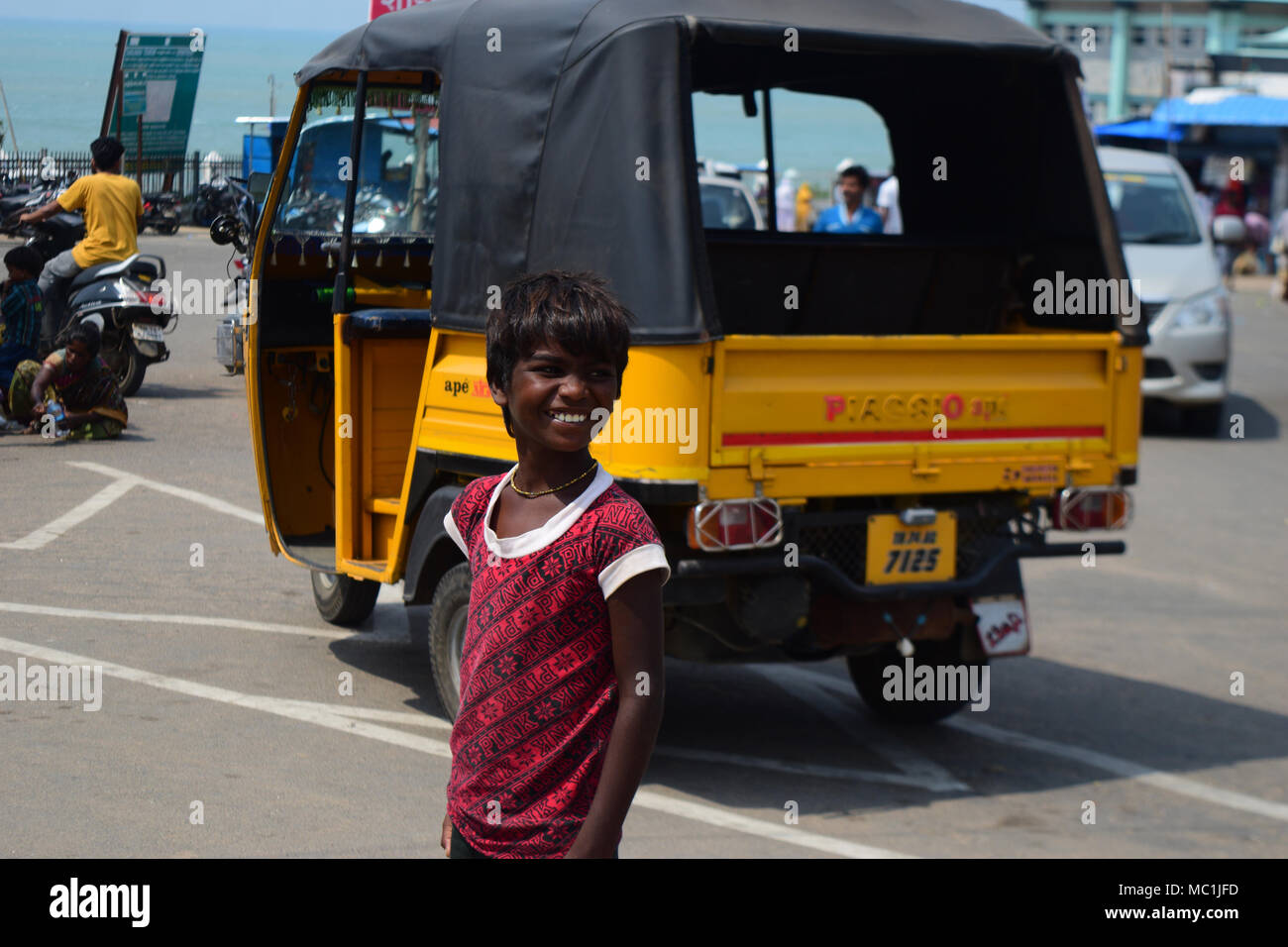 Un ragazzo indiano sorridente in piedi in una strada trafficata in india Asia Foto Stock