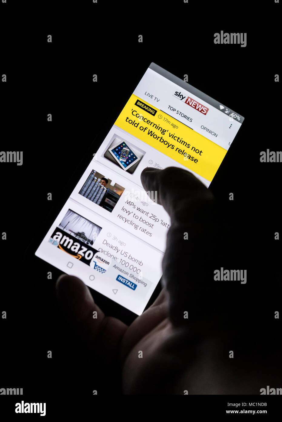 Persona che legge le notizie più recenti su uno smartphone utilizzando la Sky News app. Foto Stock