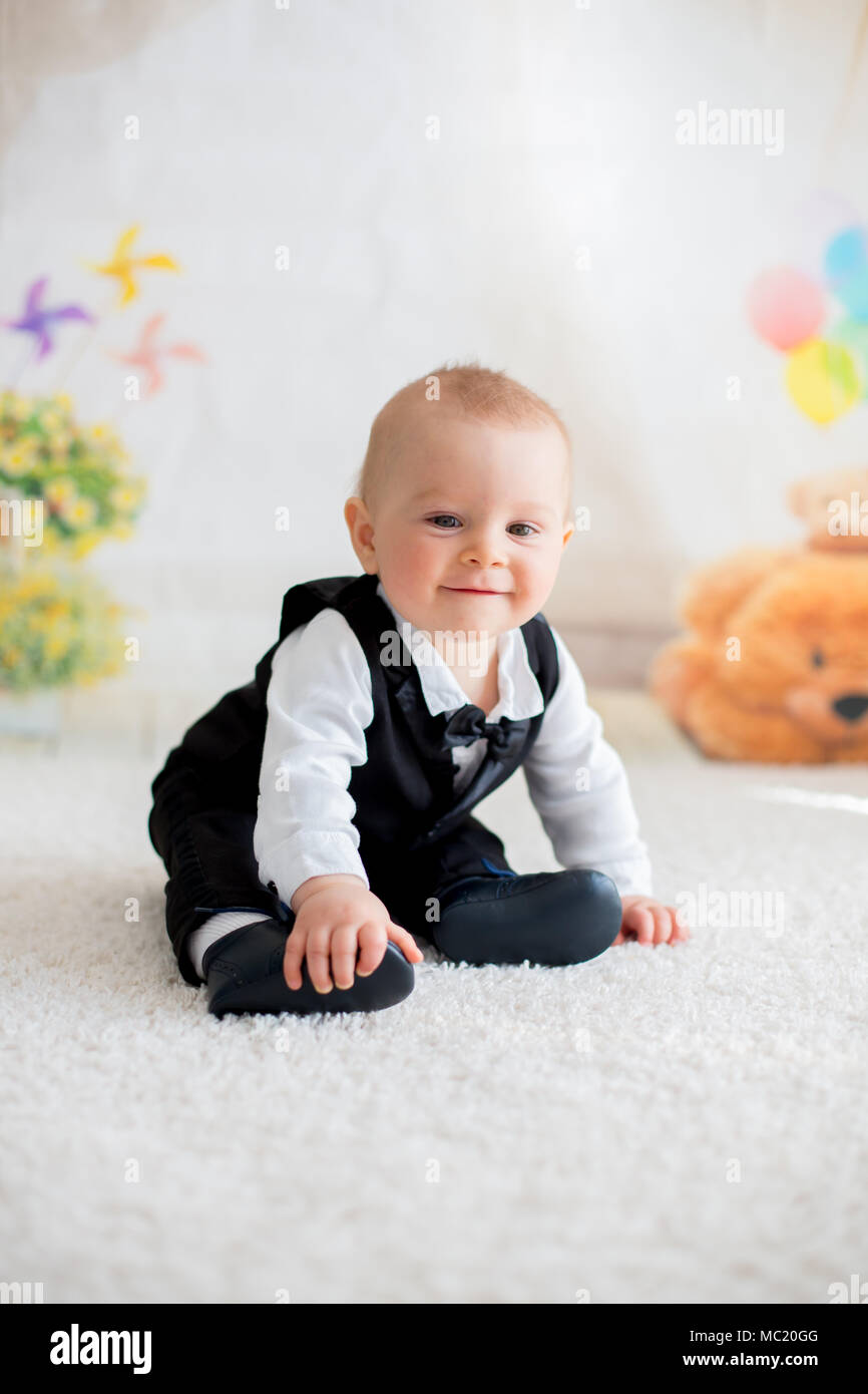 Carino piccolo bimbo boy, vestiti casual elegante, giocando con poco in  bianco e nero il coniglio a casa Foto stock - Alamy