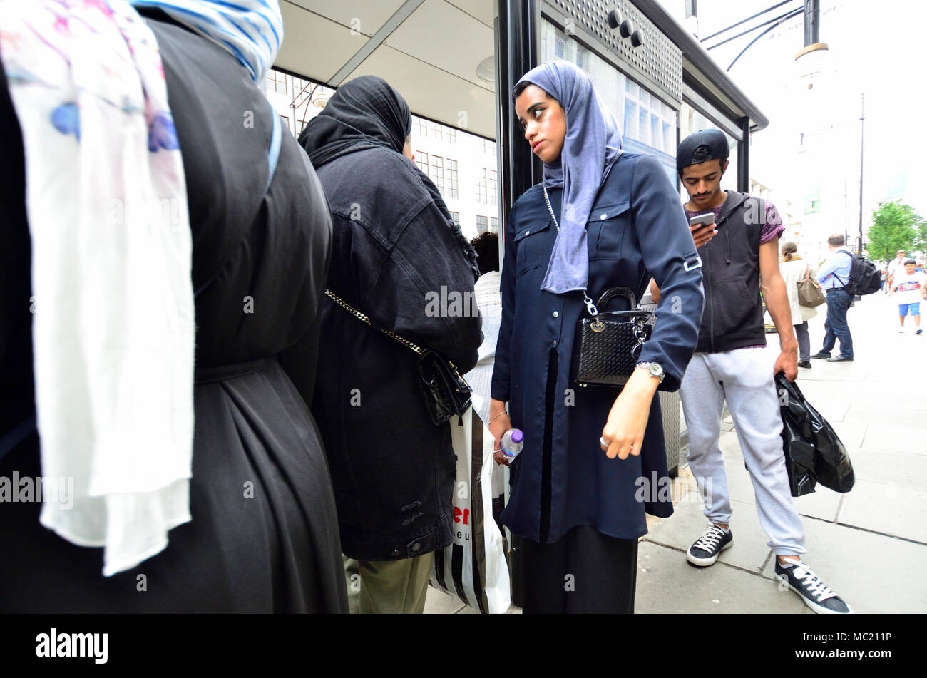 Londra, Inghilterra, Regno Unito. Le donne musulmane di indossare il velo islamico a una fermata d autobus Foto Stock