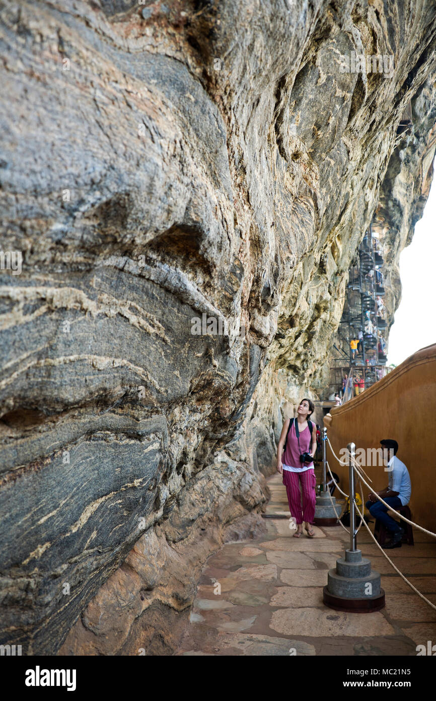 Vista verticale di un turista a piedi lungo la parete a specchio a Sigiriya o Lions Rock in Sri Lanka. Foto Stock