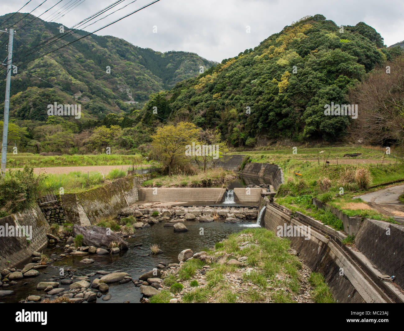 Paesaggio rurale con calcestruzzo protezione dalle inondazioni e sulla gestione fluviale, costruzione di Kunisaki, Oita, Kyushu, Giappone Foto Stock