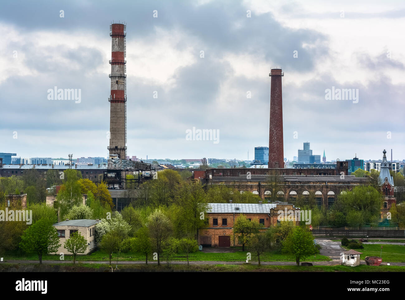 Paesaggio industriale con due tubi contro il cielo nuvoloso Foto Stock