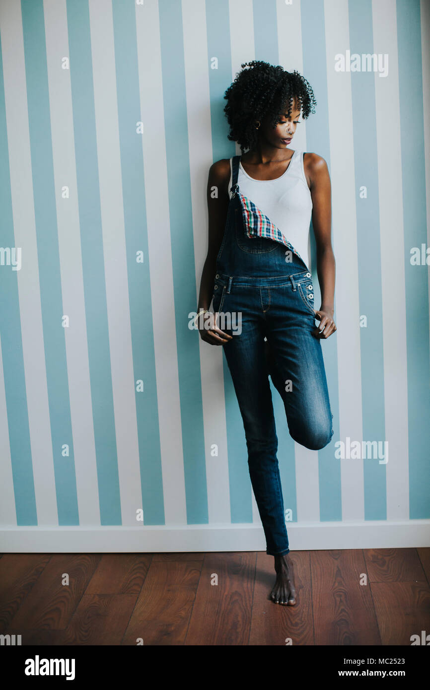 Piuttosto giovane nero donna in piedi in camera Foto Stock