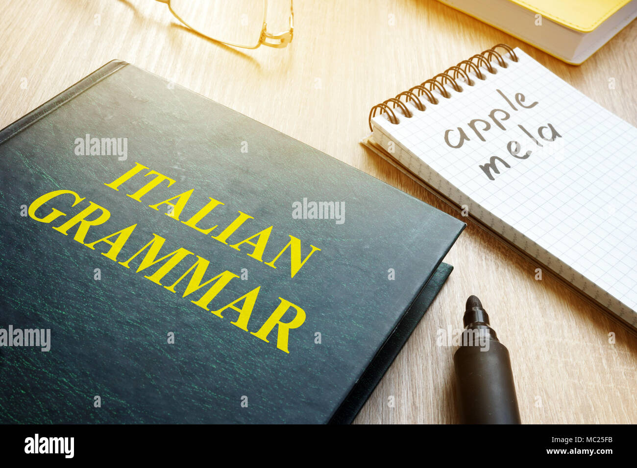 Imparare la grammatica italiana. Prenota e portatile su un tavolo. Foto Stock