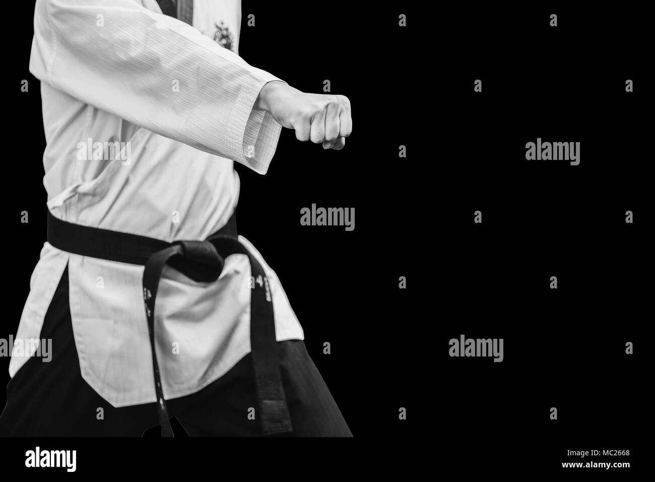 Taekwondo tradizionale coreano combattente maschio Punch pugno isolato su nero Foto Stock