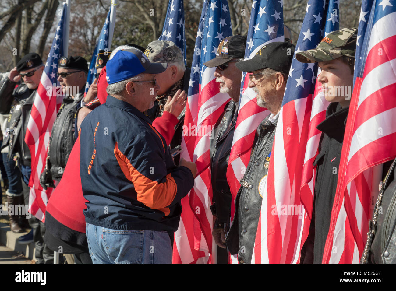 Veterani con bandierine americane a cerimonia militare. Foto Stock