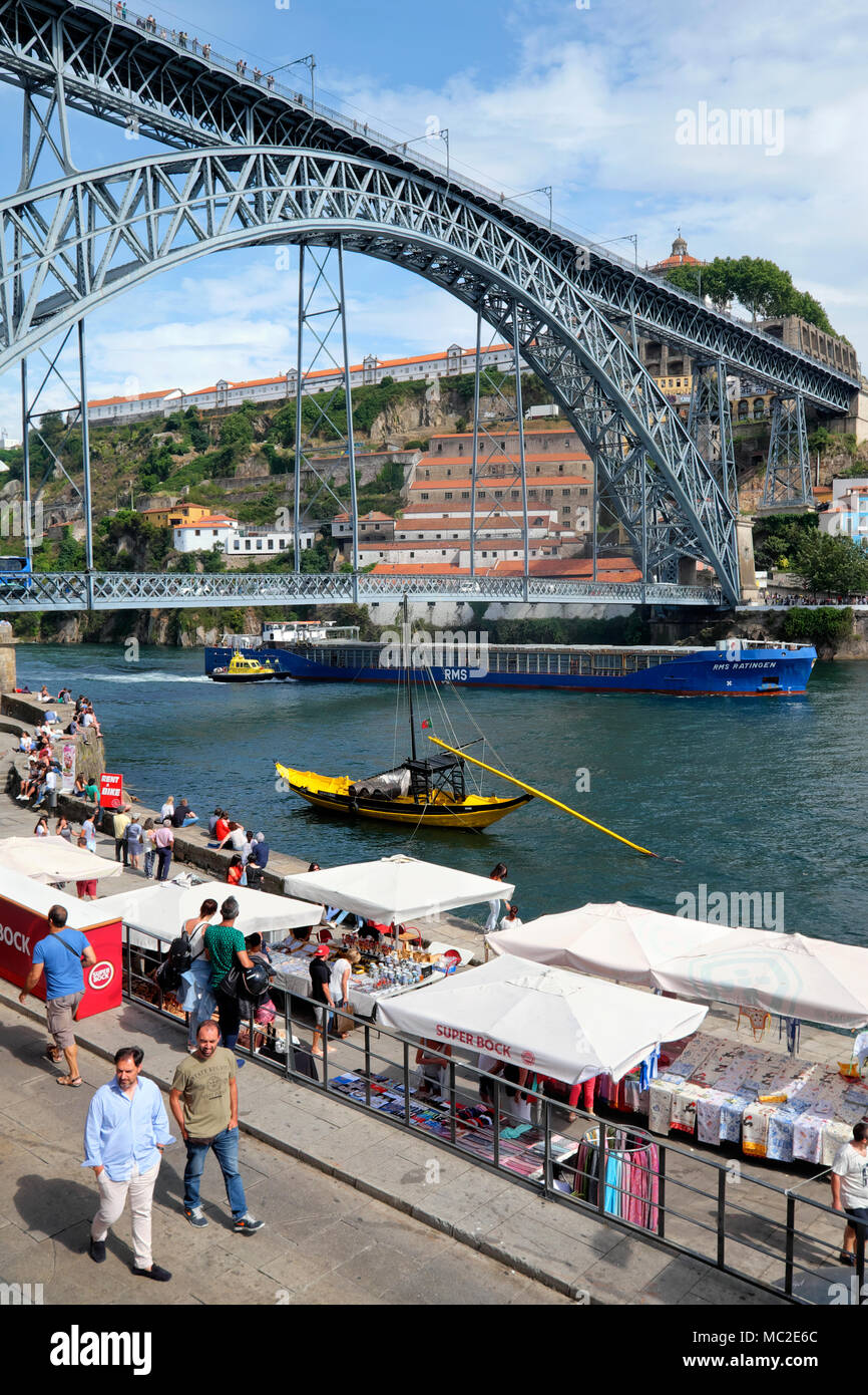 Una nave portacontainer / nave da carico passa Dom Luís I Bridge con l aiuto di un rimorchiatore a traino, Porto, Portogallo Foto Stock