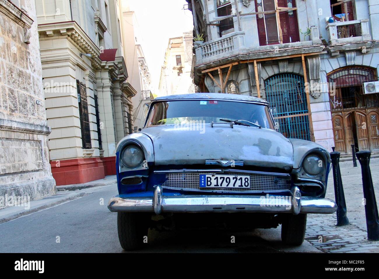 La parte anteriore di un blu vintage auto con un cubano la targa nelle strade vuote di Havana, Cuba Foto Stock