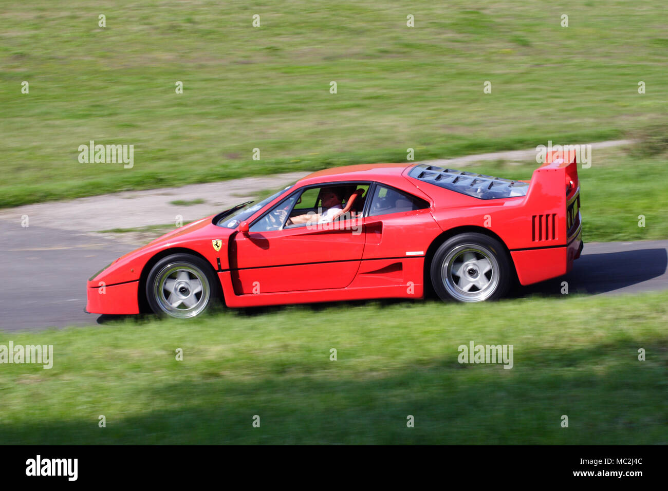 Classico rosso Ferrari F40 supercar guida veloce su un Regno Unito country road Foto Stock