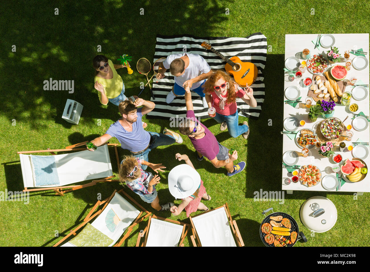 Grigliata tra i migliori amici godendo, cibo delizioso, e il clima caldo Foto Stock