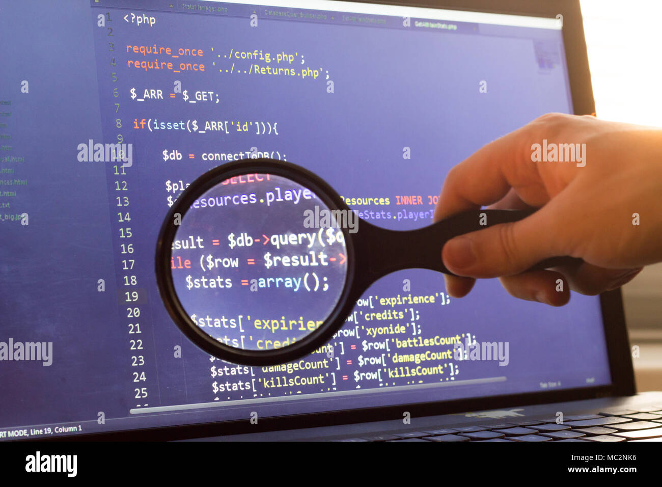 PHP back-end ingrandita del codice attraverso una lente di ingrandimento. Programmazione di computer il codice sorgente di ricerca. Schermo astratto di web developer. Il codice è creato da me. Foto Stock