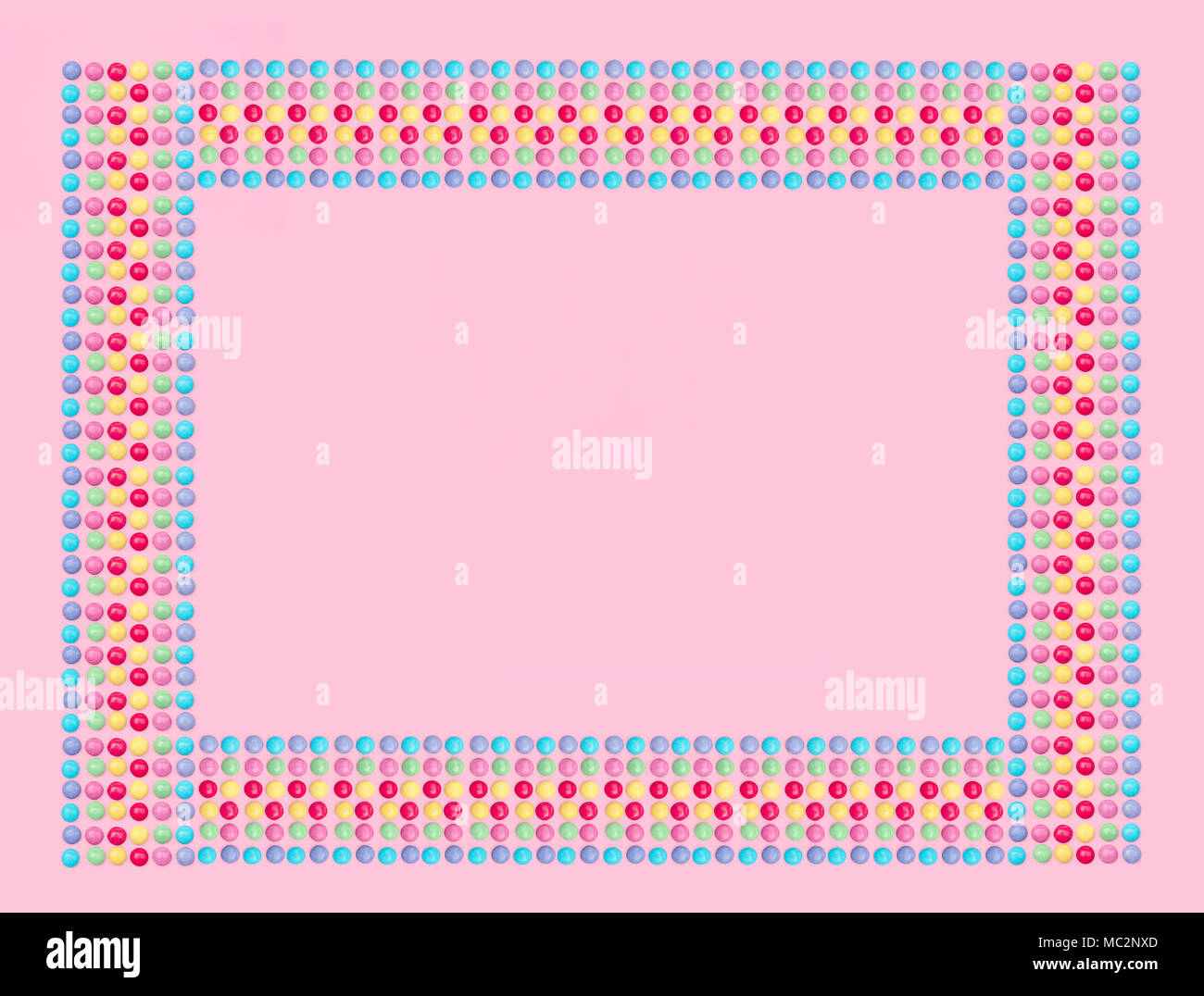 Un assortimento di caramelle colorate su sfondo rosa. Foto Stock