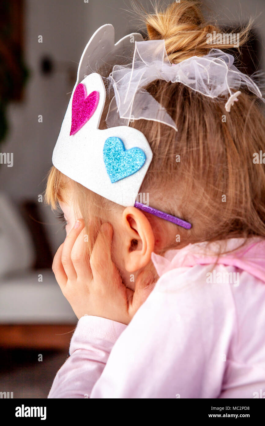 Bambina vestita come la principessa di guardare la televisione. Foto Stock